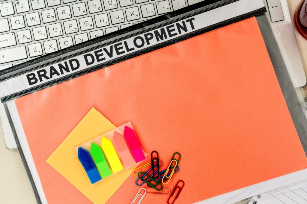 Top view of a folder labelled "BRAND DEVELOPMENT" on a laptop in the office